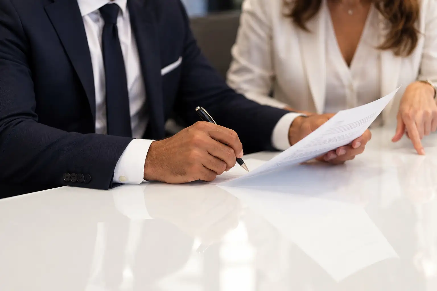 Un avocat, stylo en main, relit un document avec sa cliente
